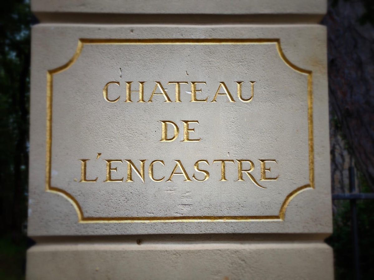 The estate's engraved stone entrance pillar reading Château de L'Encastre.