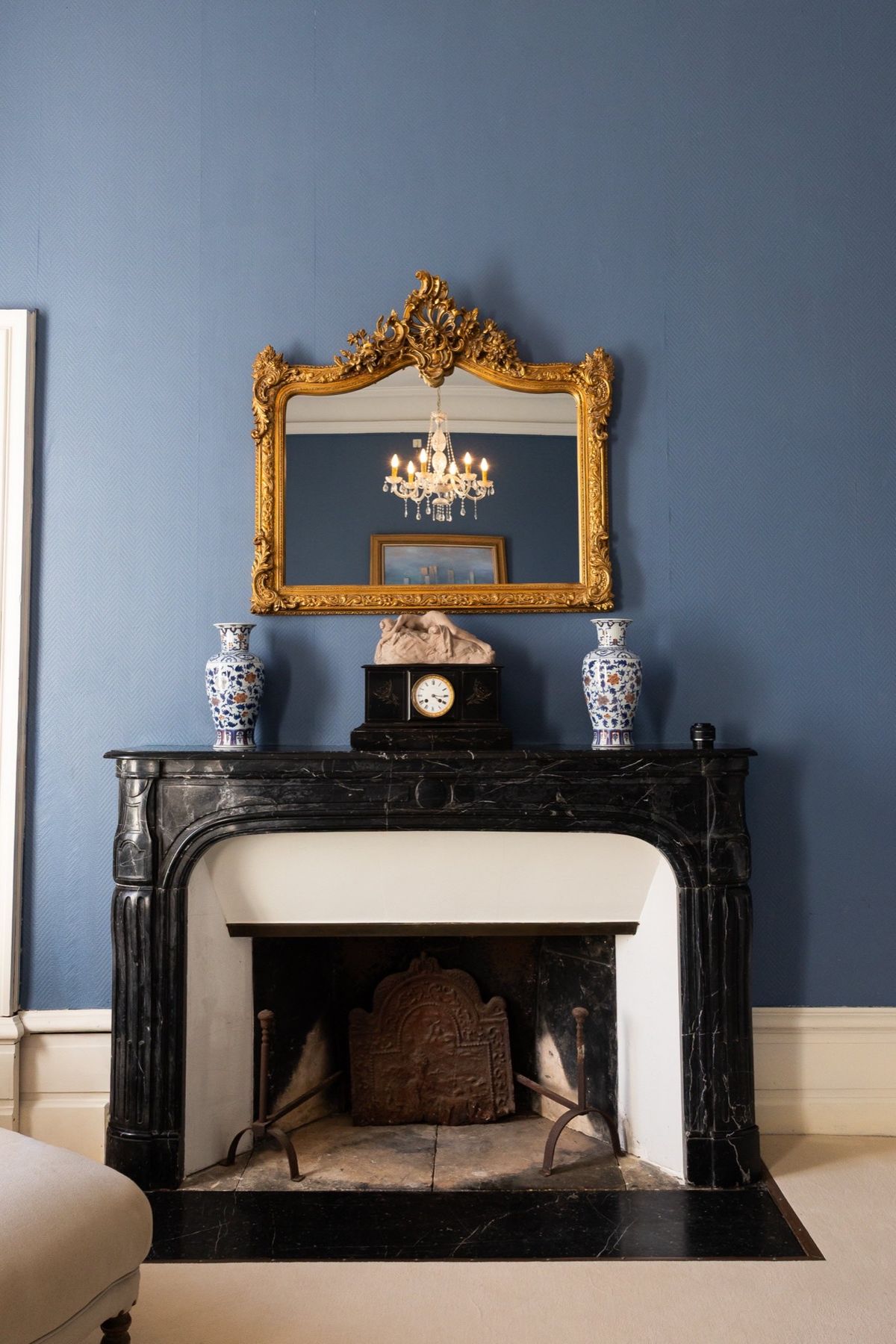 Black marble fireplace and gilt overmantel mirror in the bridal suite at Chateau du Pordor