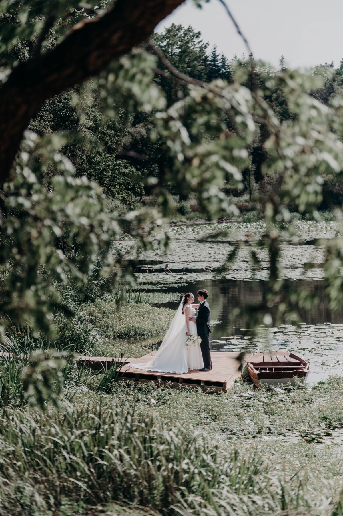 A couple on the wooden jetty over the lily lake at Chateau du Pordor
