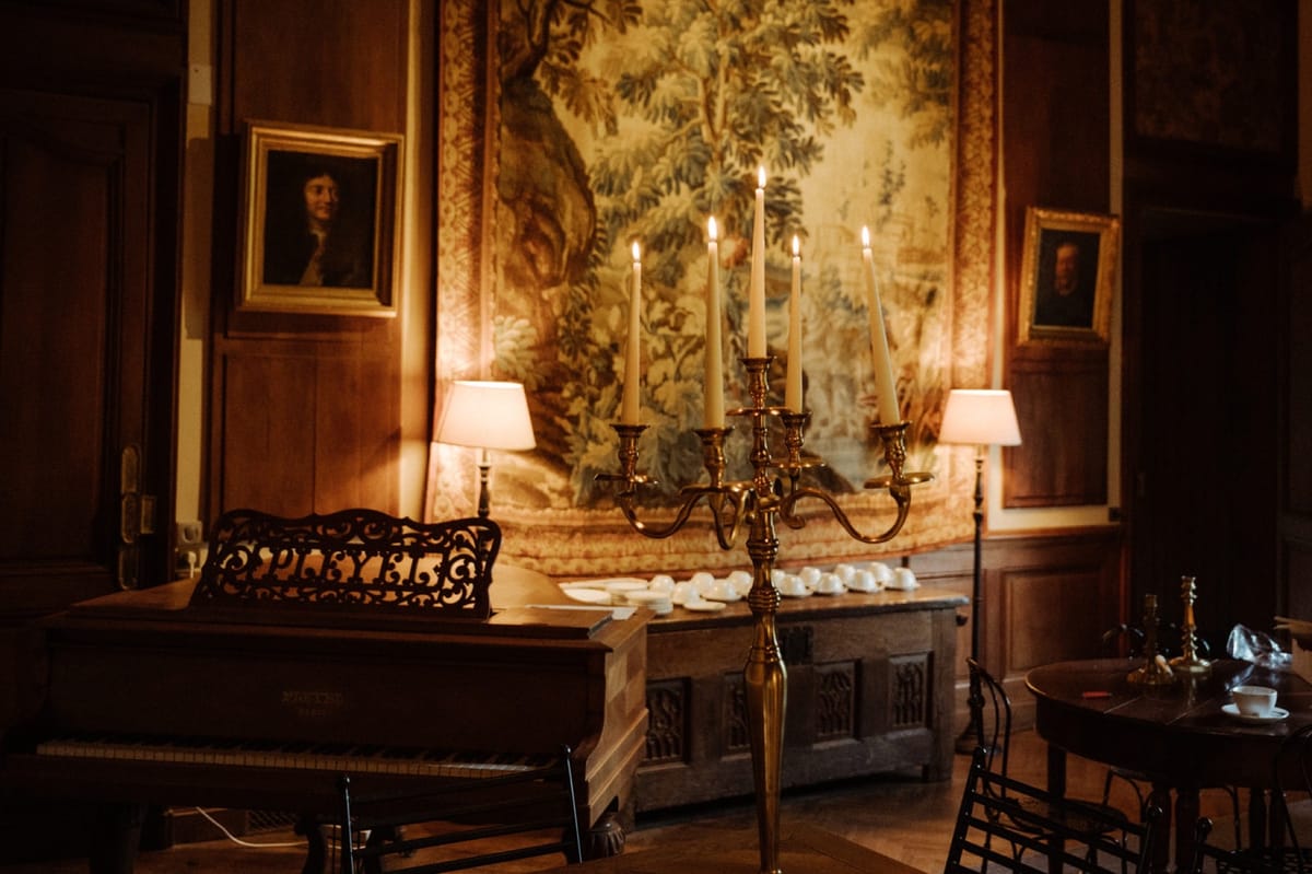 Panelled salon at Chateau du Pordor with a tapestry, candelabra and antique furniture
