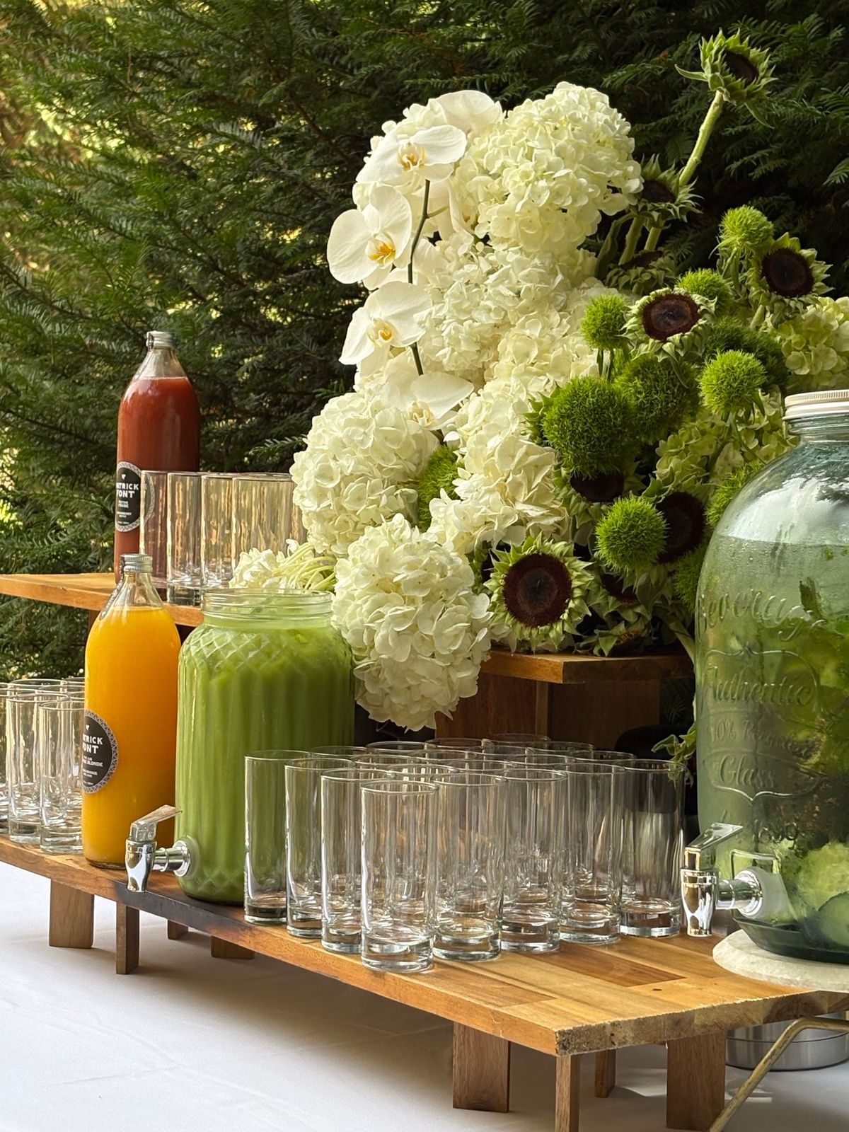 Drinks table set for Sunday brunch at Chateau du Pordor, with juices and white floral arrangements