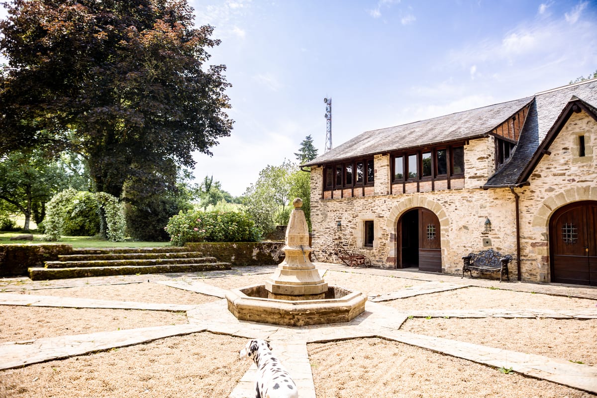 Chateau Eyparsac stone and timber facade overlooking the gravel forecourt and fountain