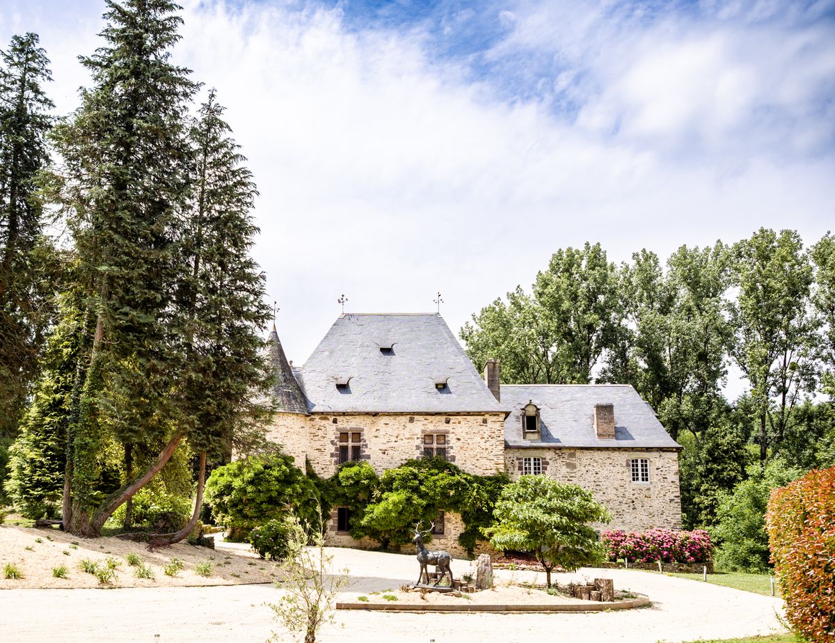 Chateau Eyparsac framed by its gardens with a turret and slate roof