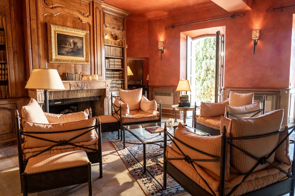 Library salon with bookcases and fireplace at Chateau les Crostes