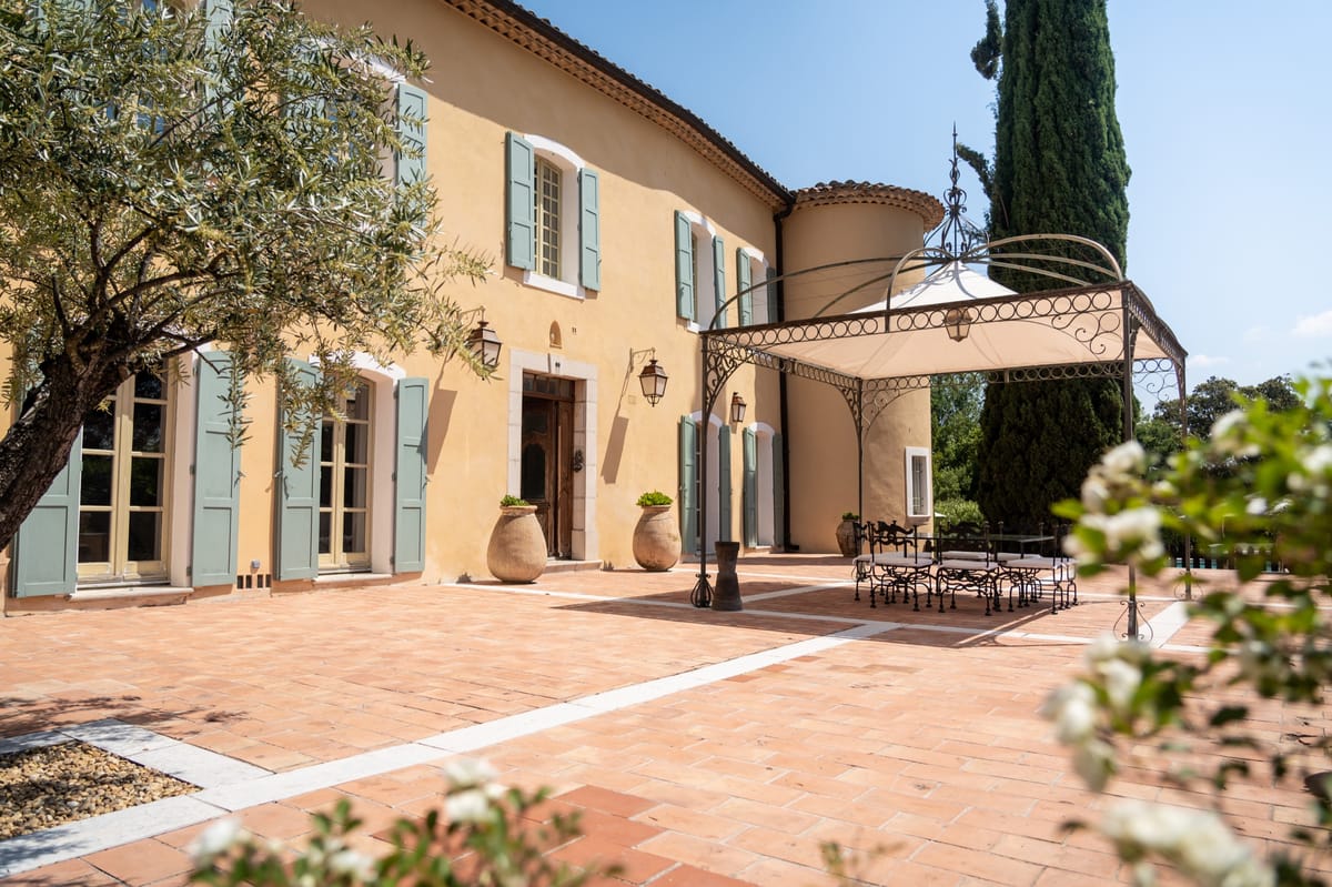 Terrace with wrought-iron pergola beside the facade at Chateau les Crostes