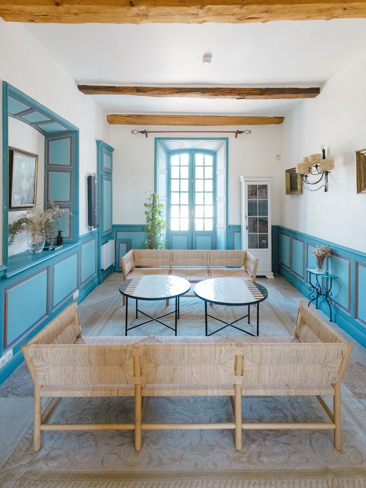 Blue-panelled salon with woven seating at Chateau les Crostes