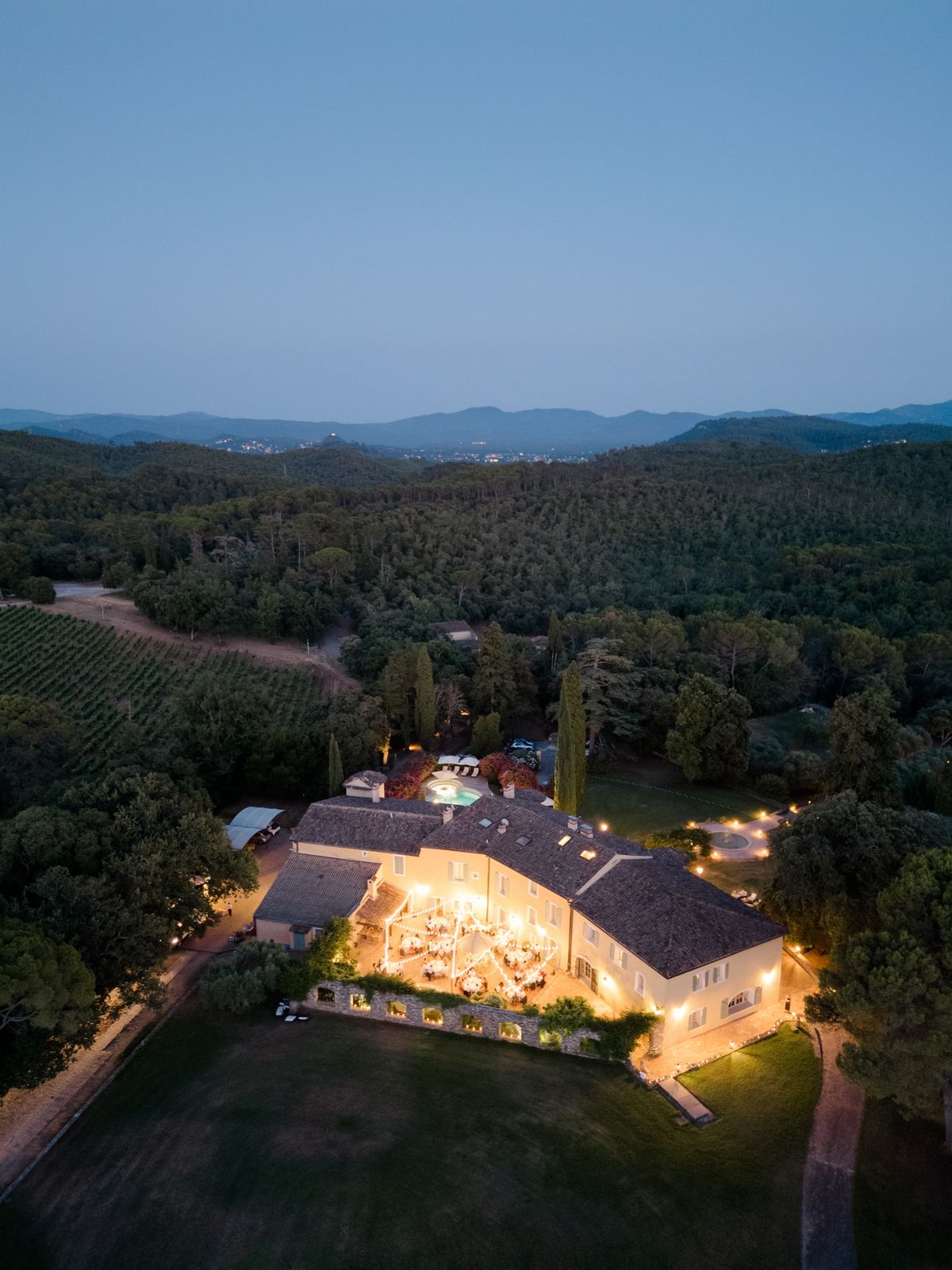 Chateau les Crostes lit at dusk during a wedding reception on the terrace