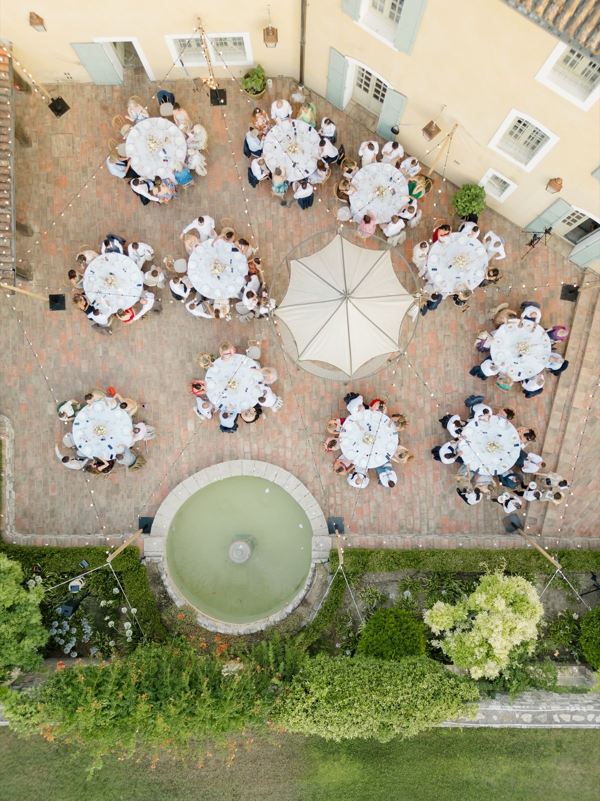 Wedding tables arranged around the courtyard fountain at Chateau les Crostes
