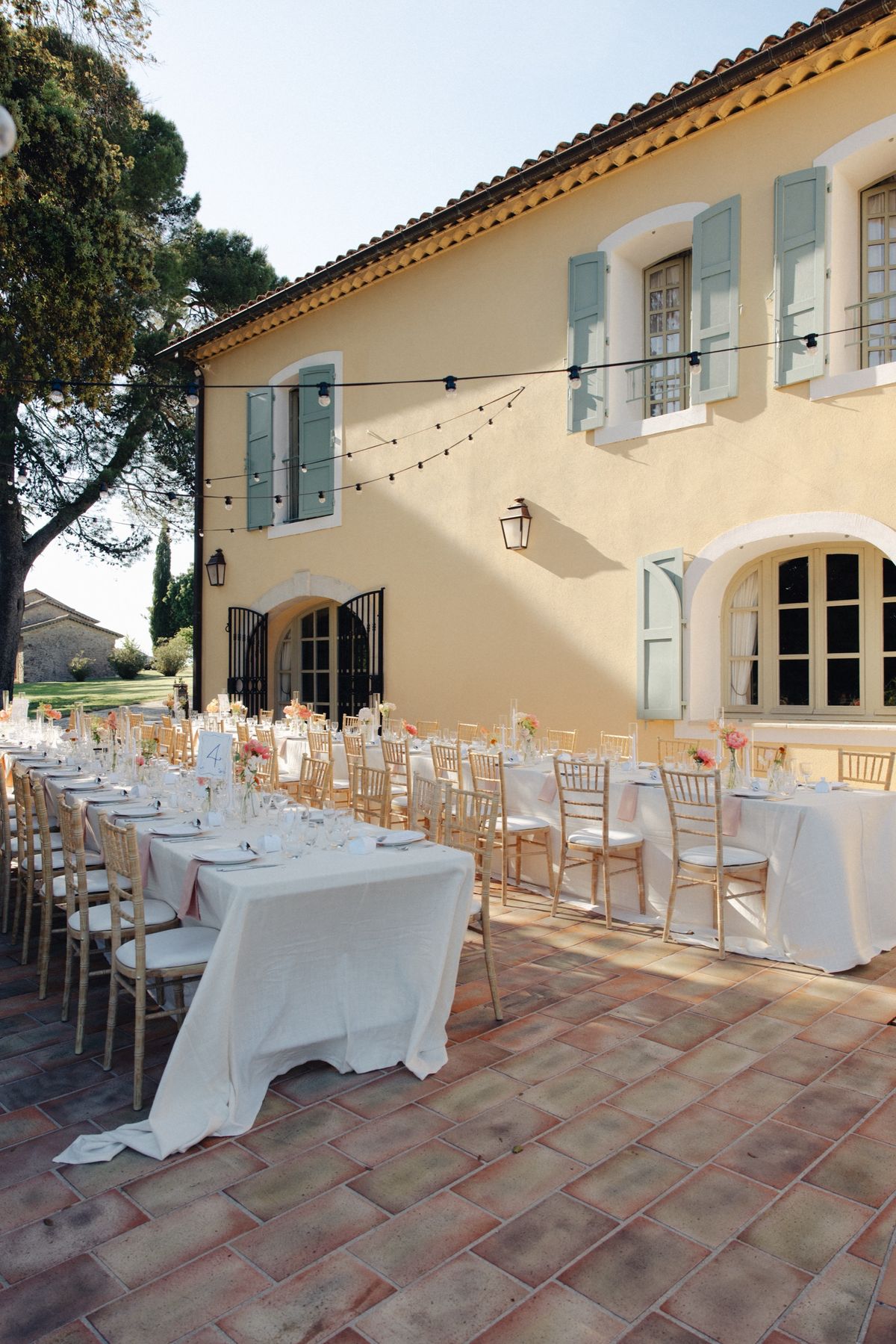 Long wedding tables on the terrace beside the facade at Chateau les Crostes