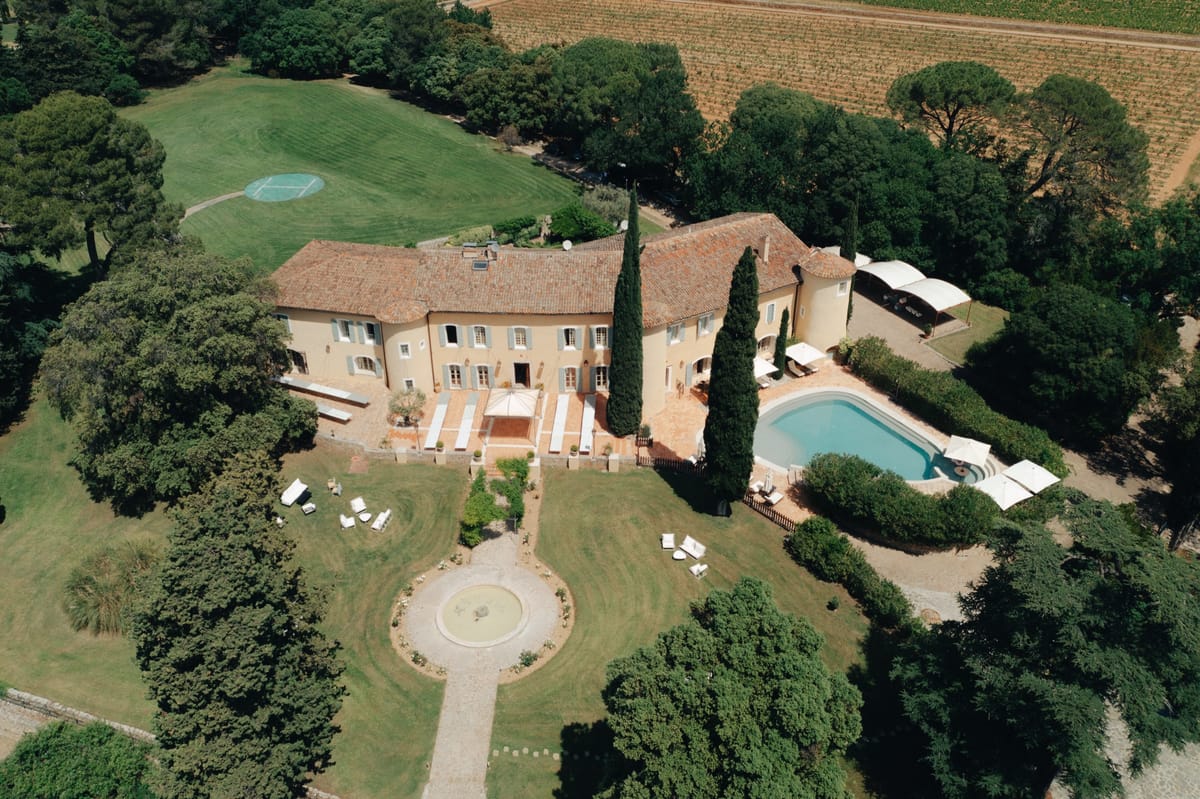 Aerial of Chateau les Crostes with its pool, terrace and garden fountain, vineyards beyond