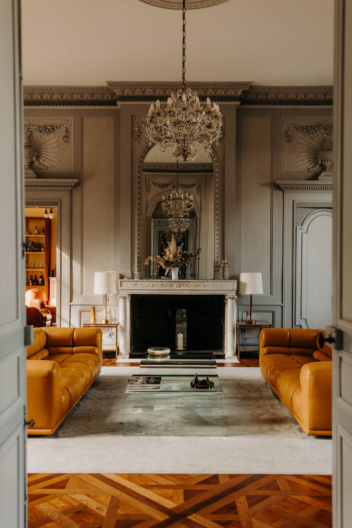 Second view of the grand salon at Chateau de l'Hospital, framed by the double doorway into the adjoining room