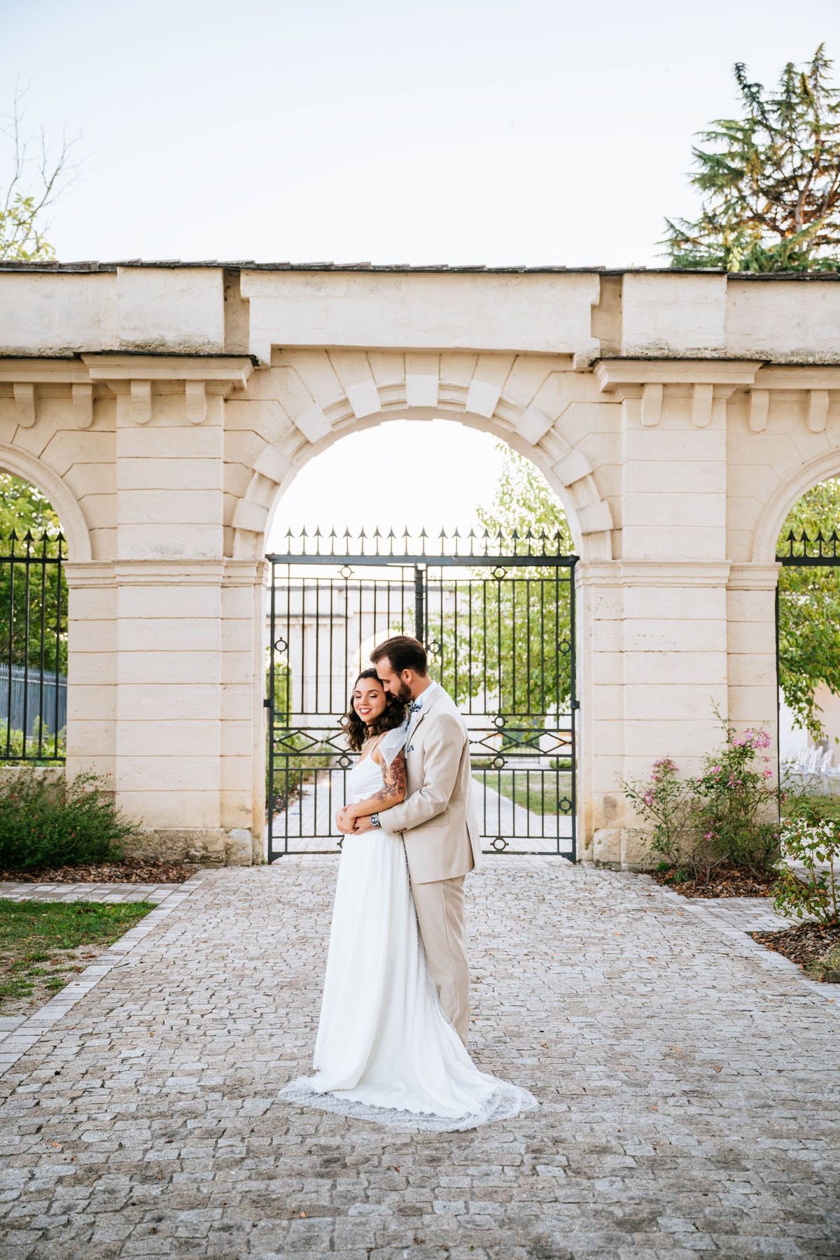 Couple portrait at the stone gateway arch of Chateau de l'Hospital