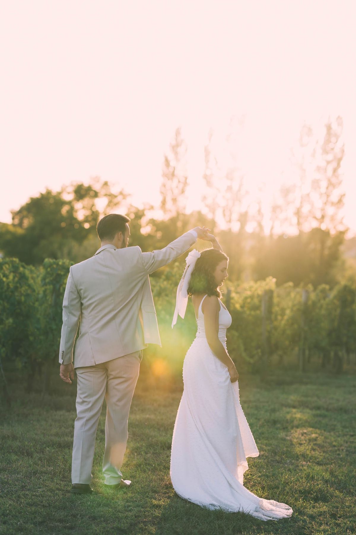 The couple dancing between vineyard rows at Chateau de l'Hospital during golden hour