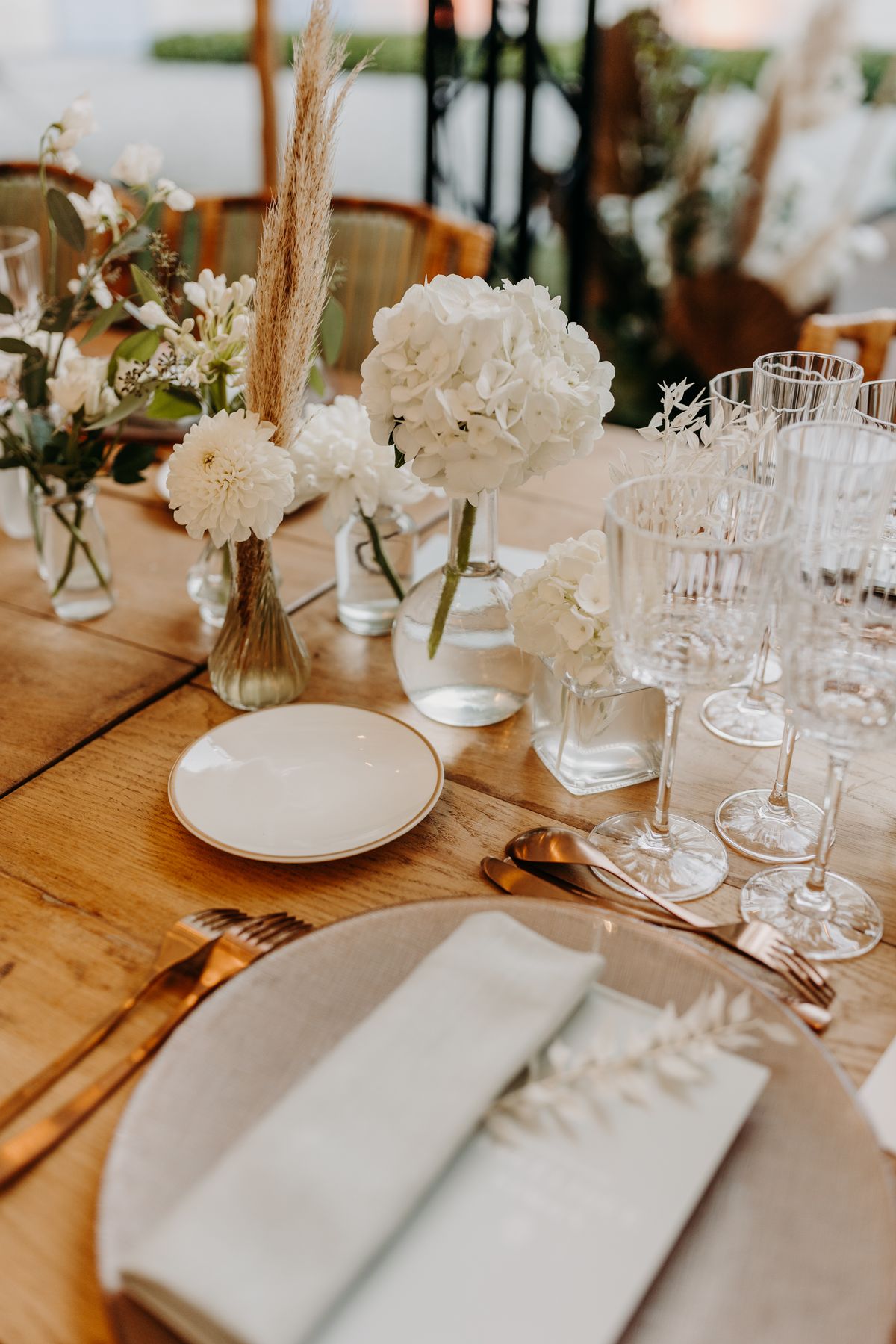 A close-up of the reception table styling with white hydrangea and dahlia arrangements in glass bud vases
