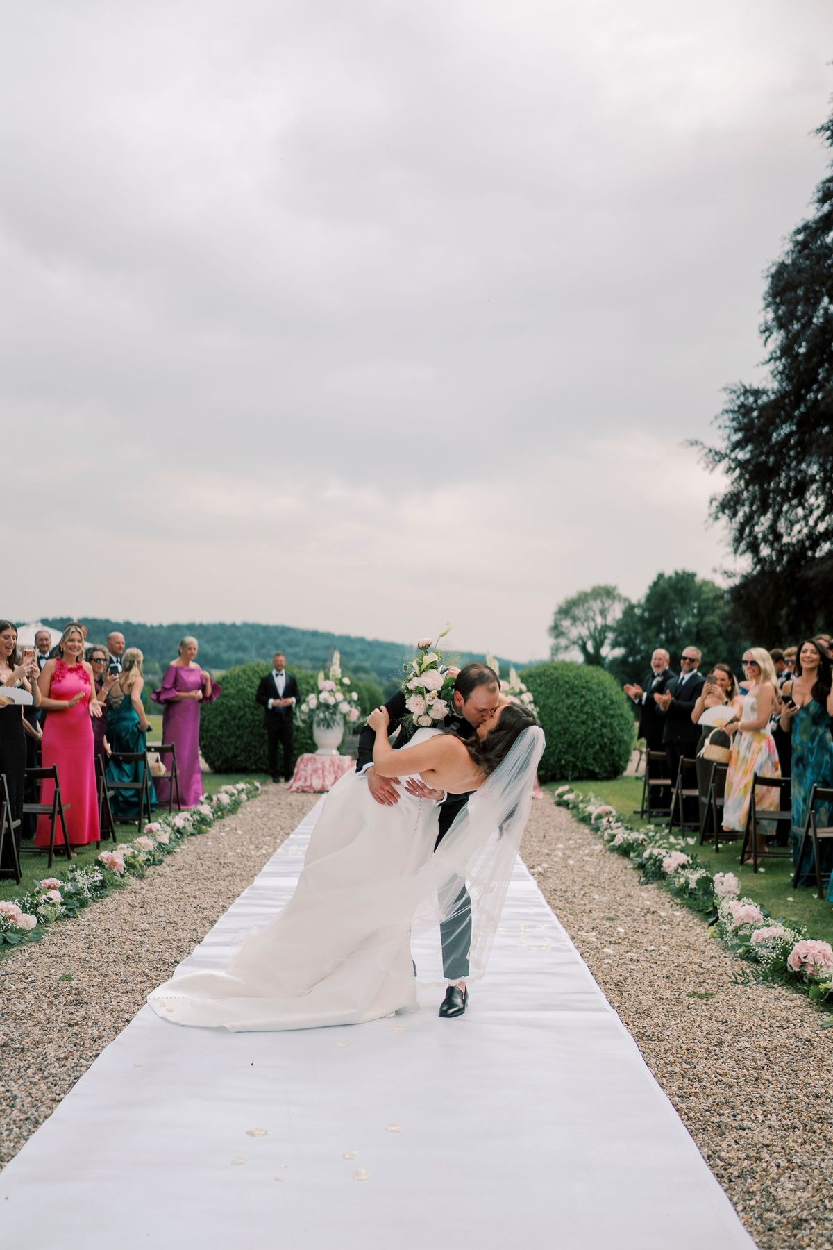 The ceremony aisle lined with guests and flowers looking out over the valley