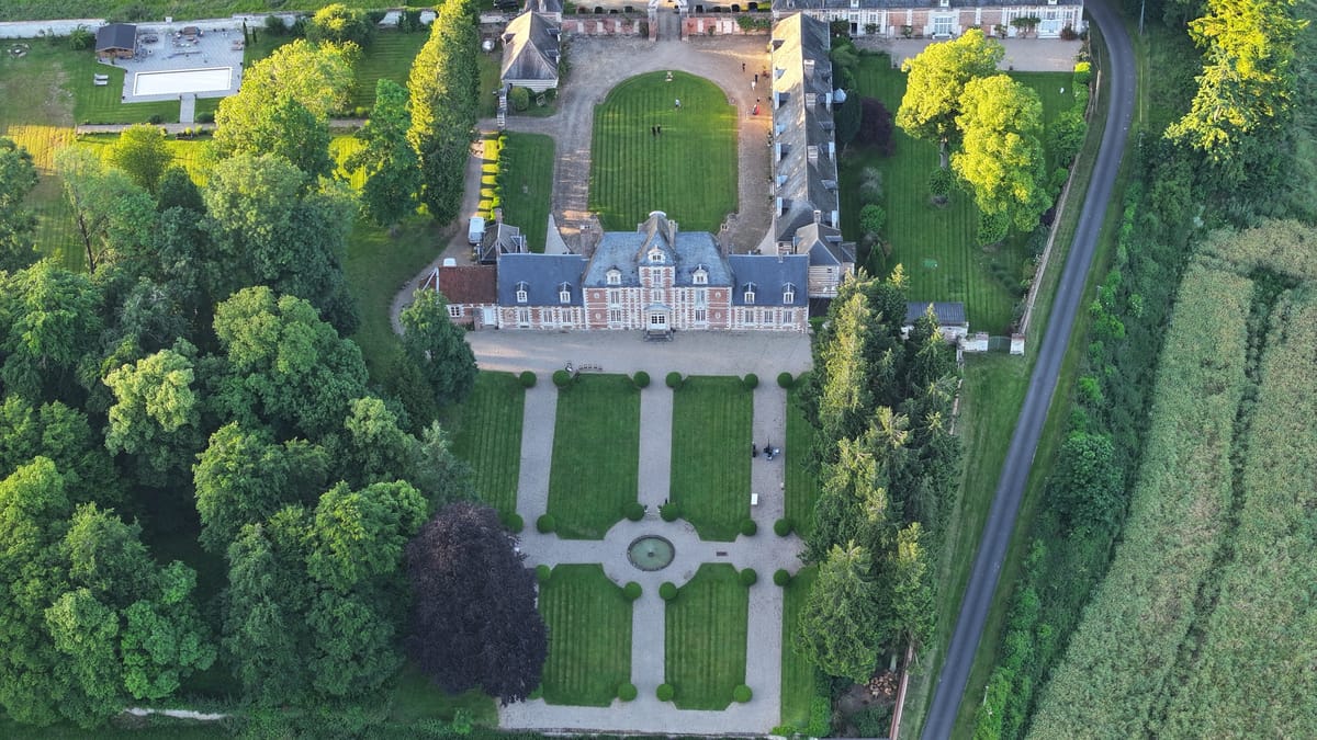 Aerial view of the château with its formal parterre gardens and tree lined approach