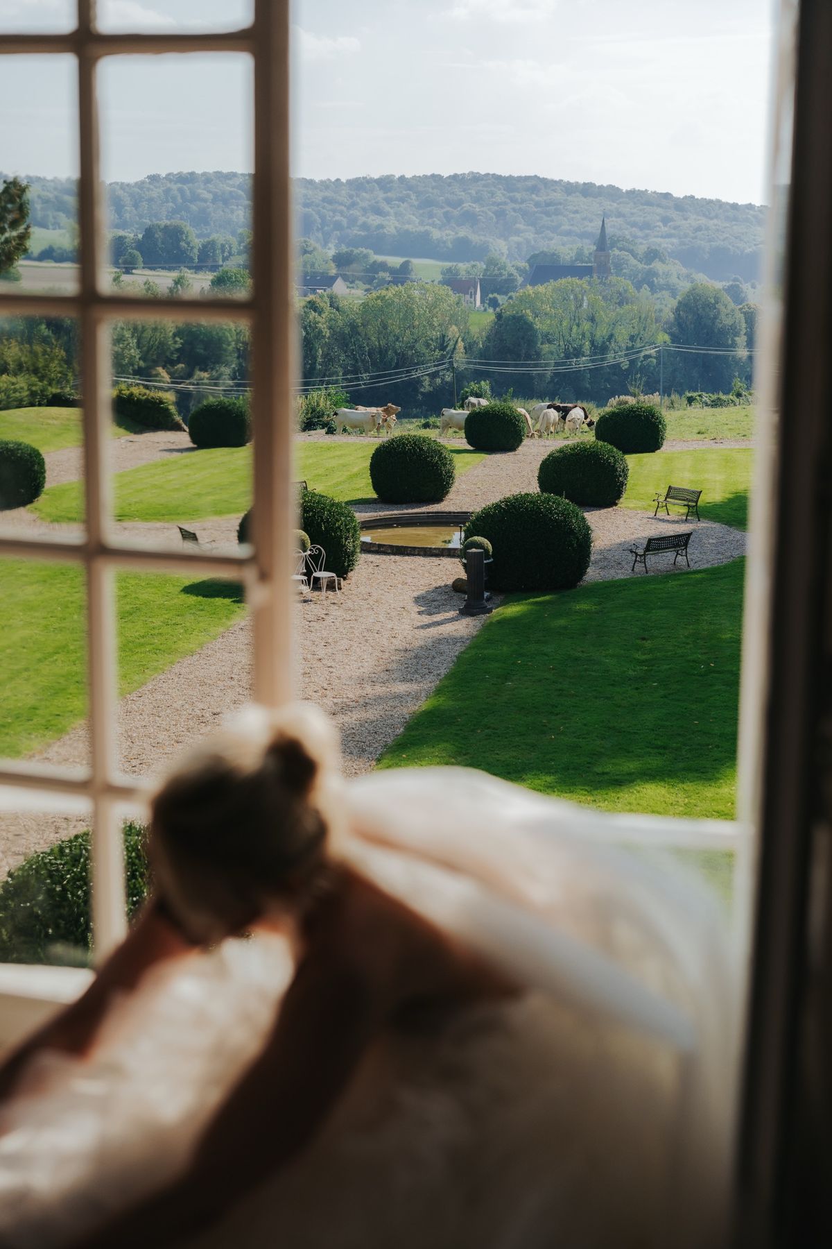 The formal garden with clipped topiary spheres, a circular basin and the valley beyond