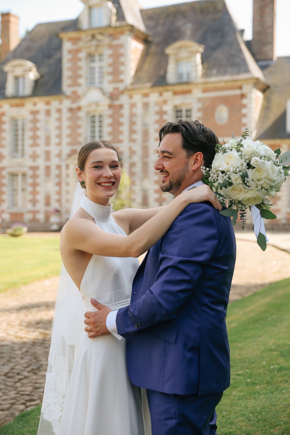 A couple on the lawn with the château facade behind them