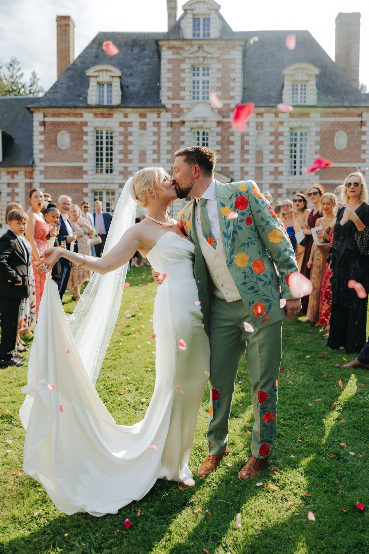 Guests throwing petals on the front lawn with the château behind