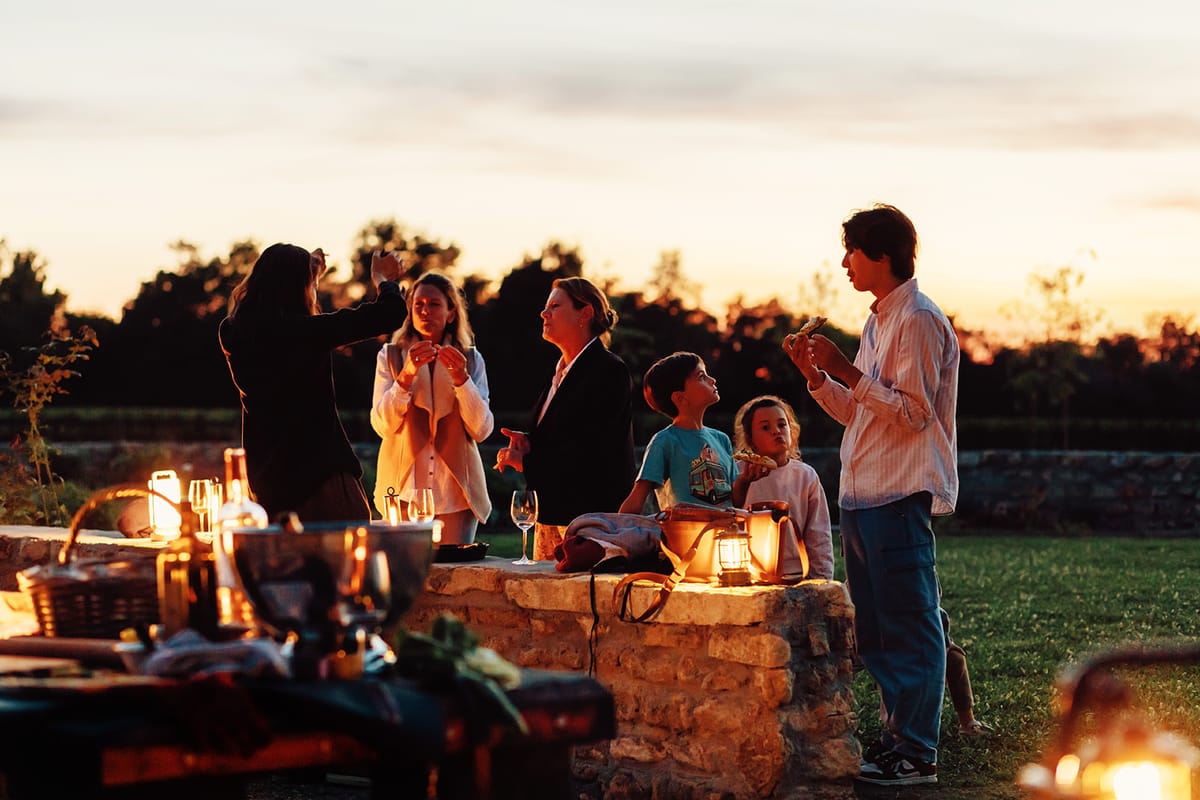 Château de Beaulieu — Guests at the stone-wall bar, dusk
