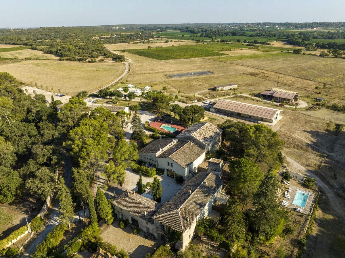 Aerial view of the estate hamlet with its swimming pool and white event marquees among the trees.