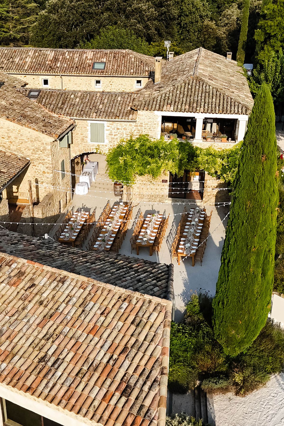 Elevated view of courtyard banquet tables and wooden chairs at Domaine de Valbonne