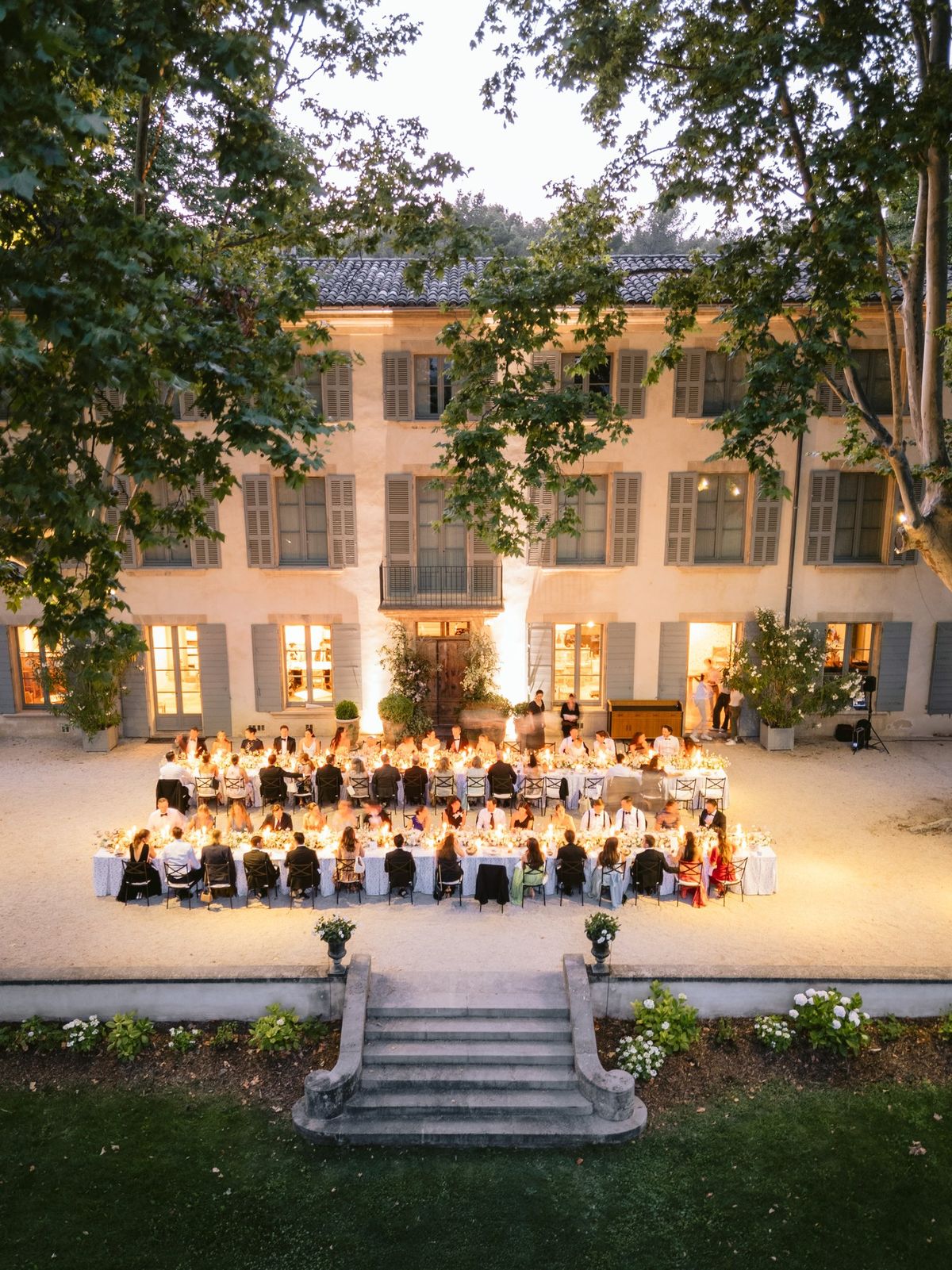 Evening reception dinner on the lawn with the illuminated chateau behind