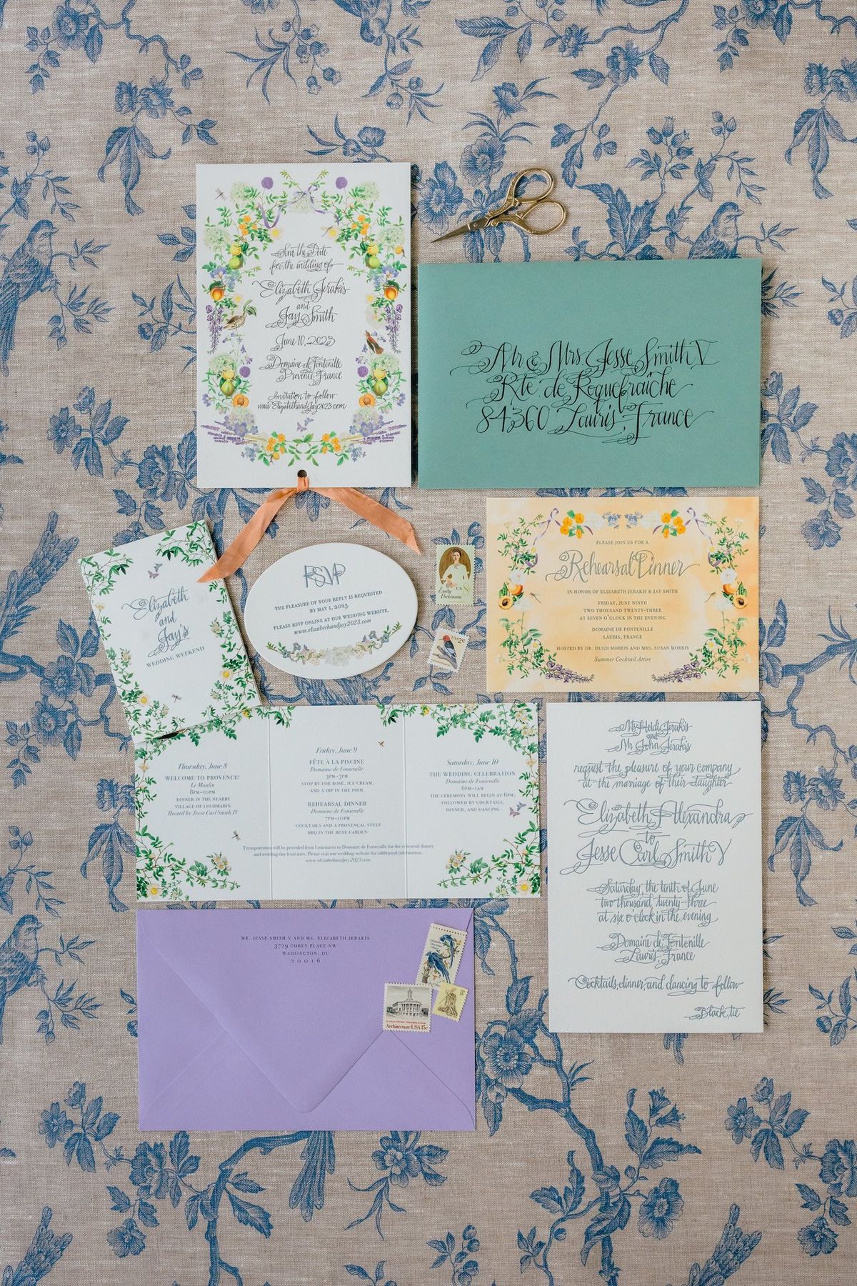 Wedding stationery suite laid out on a floral tablecloth