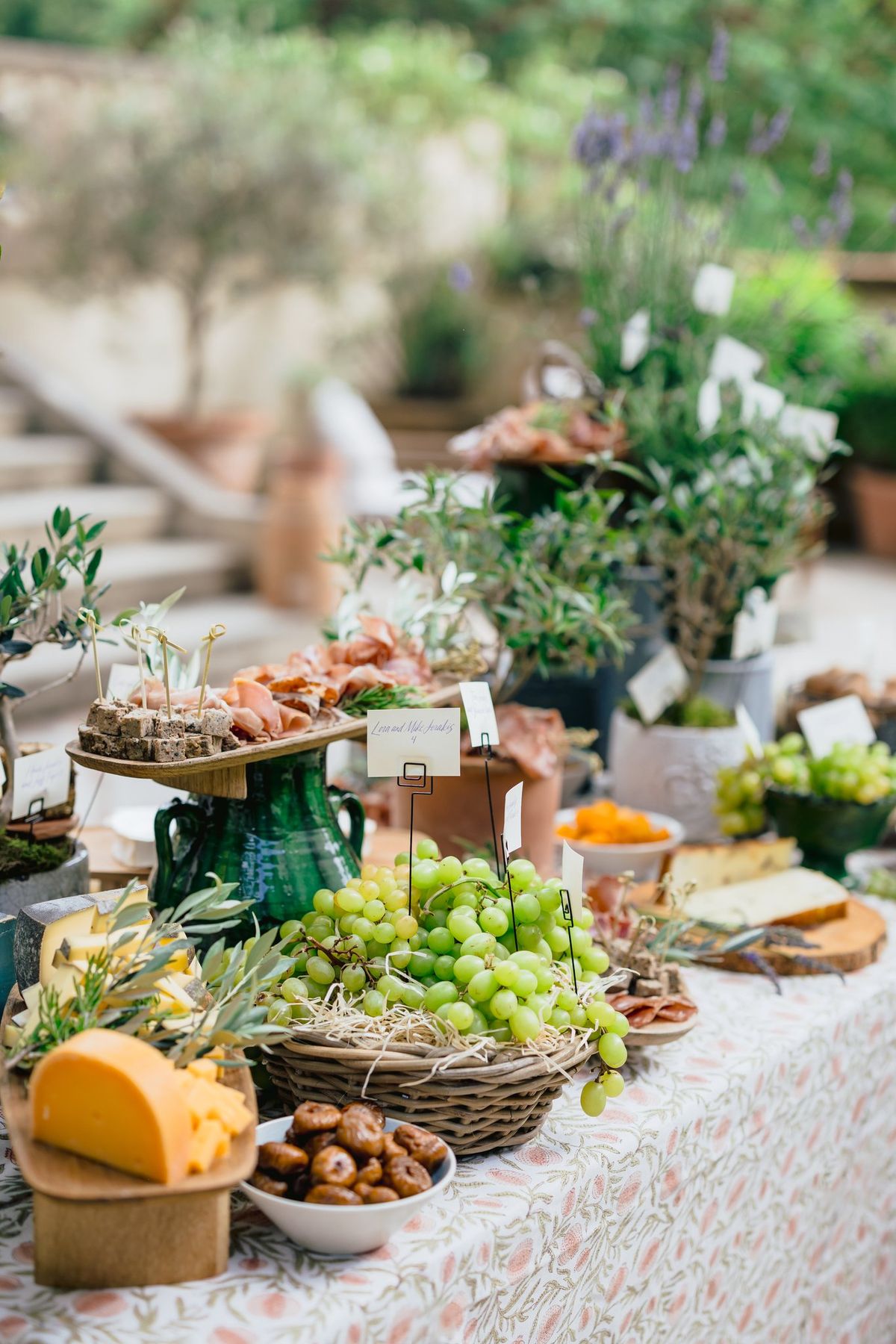 Grazing table with herbs and produce set on a stone surface