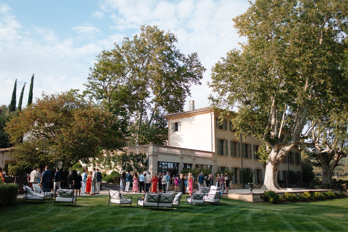 Guests gathered on the lawn near the cypress trees and chateau