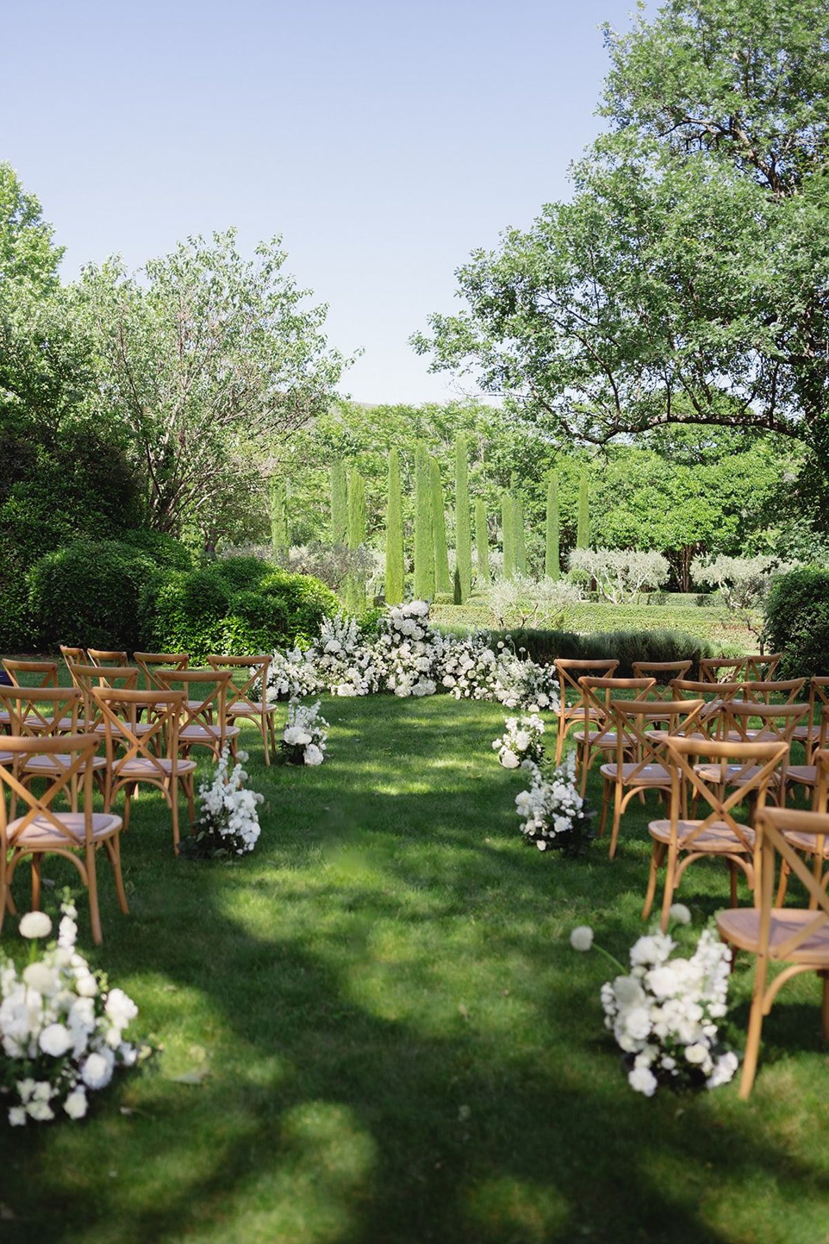 Empty ceremony rows set on the lawn with floral aisle markers