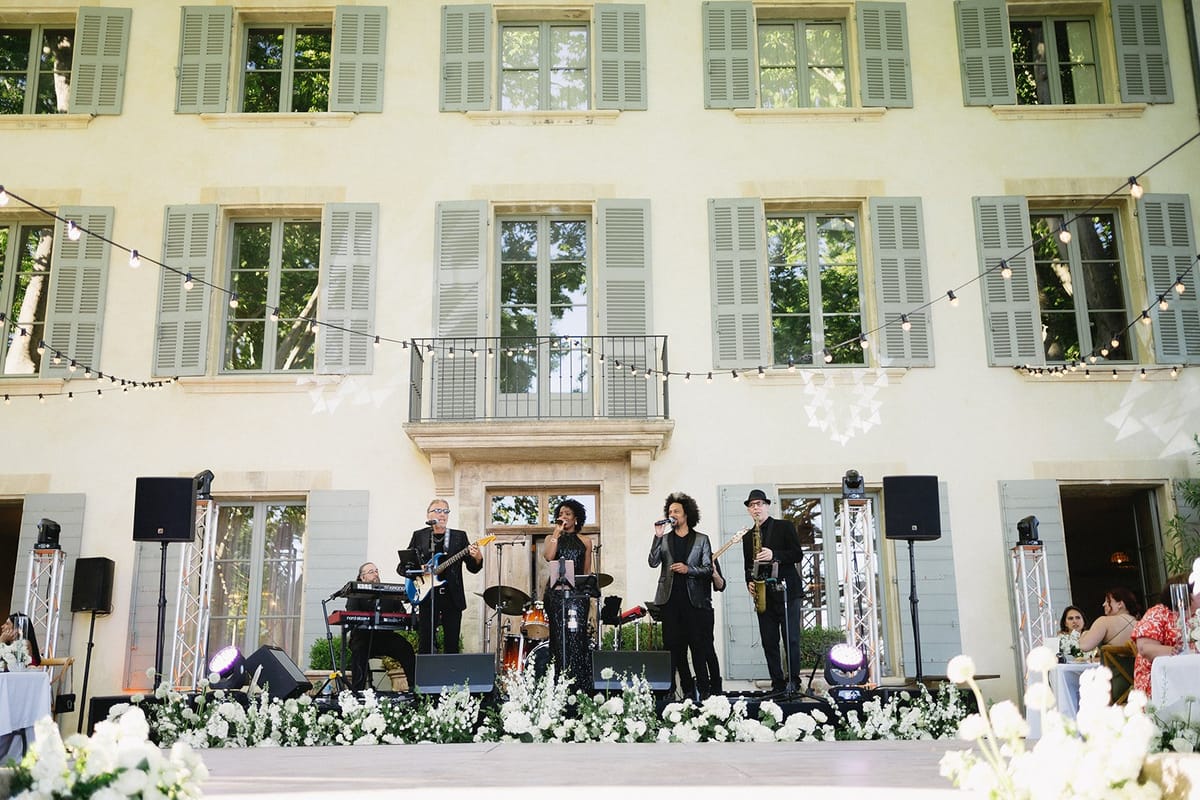 Chateau facade illuminated at dusk with live music playing