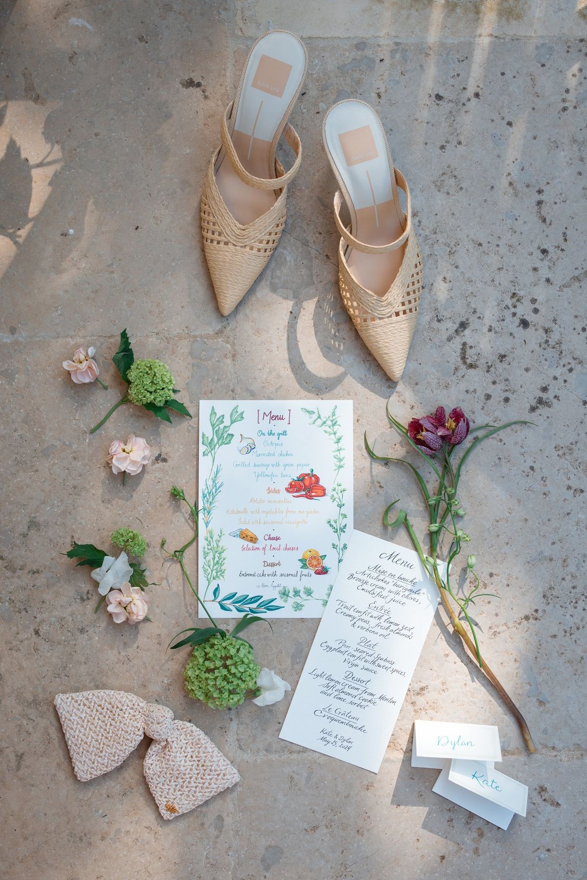 Flatlay of wedding shoes, stationery and florals