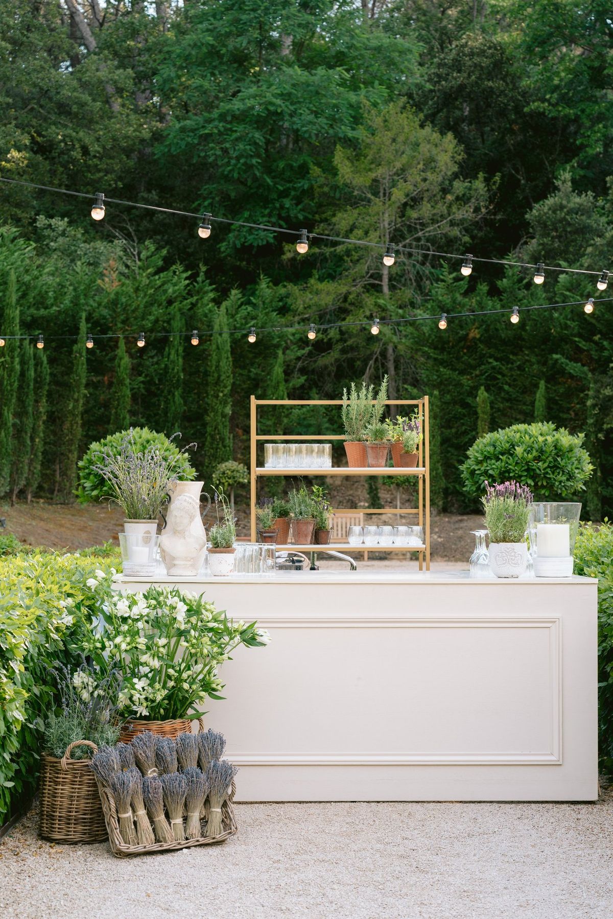 Outdoor bar station styled with greenery and string lights