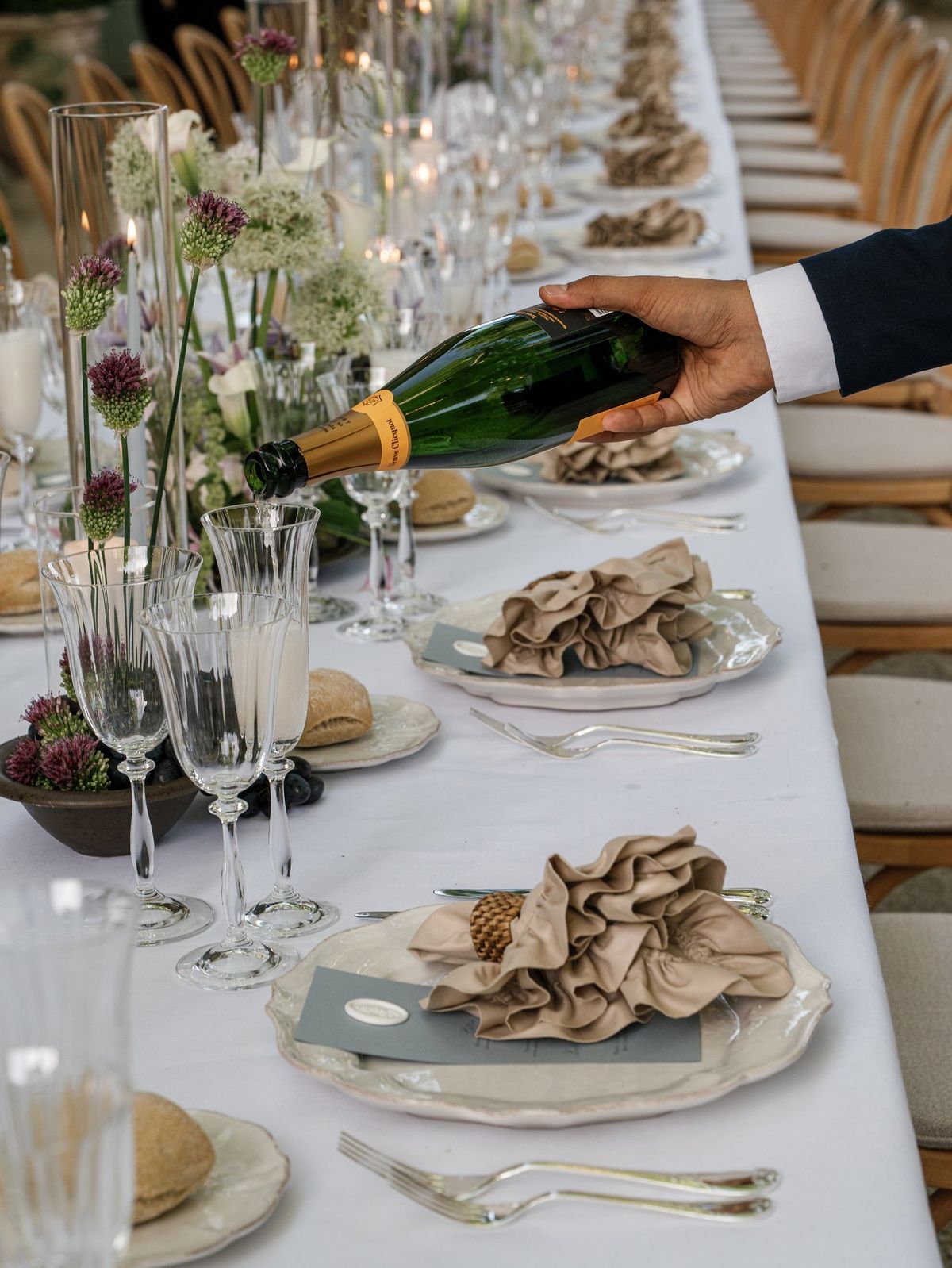 Champagne being poured at a set dinner table