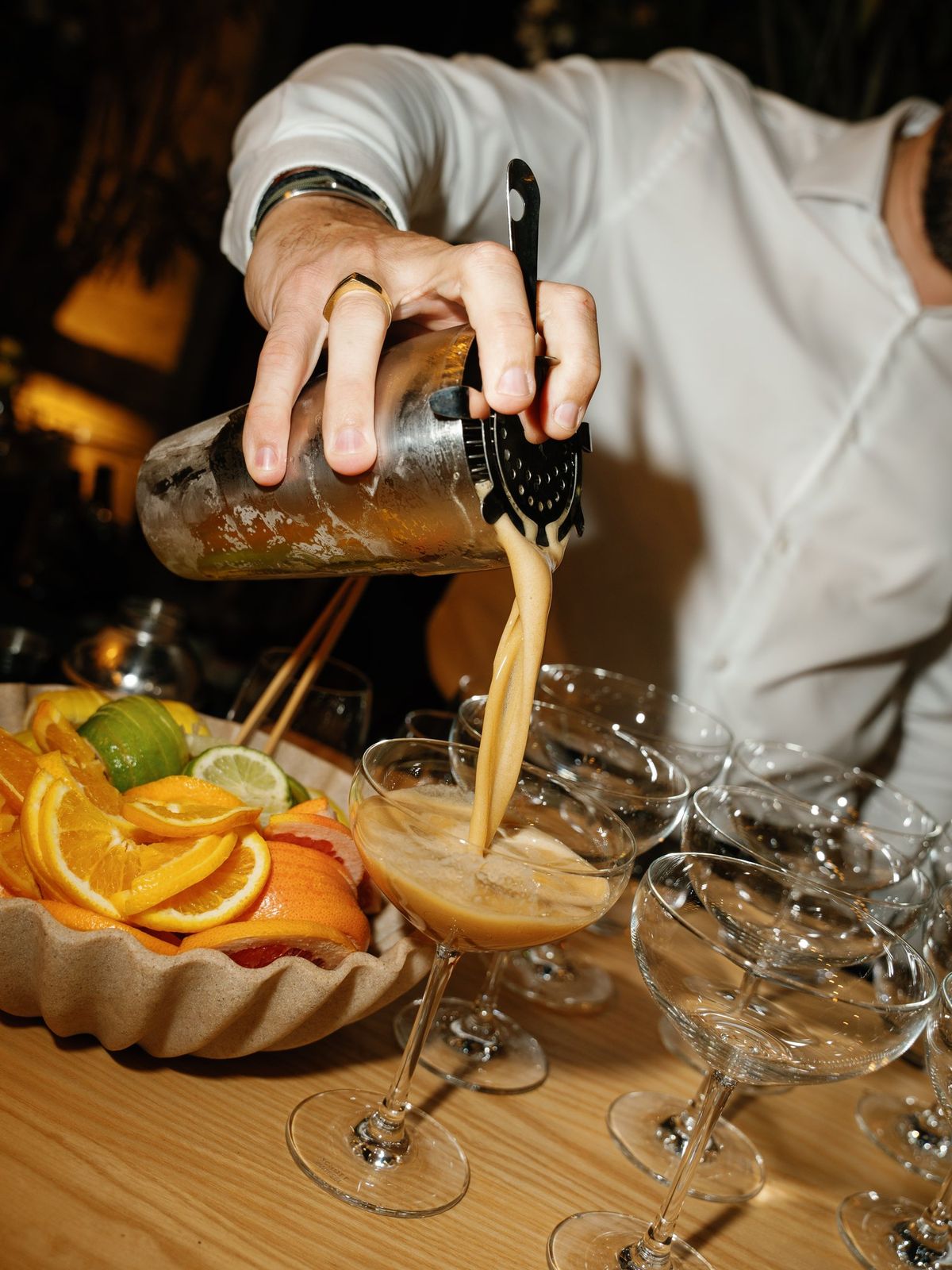 Cocktail being poured over citrus at the bar