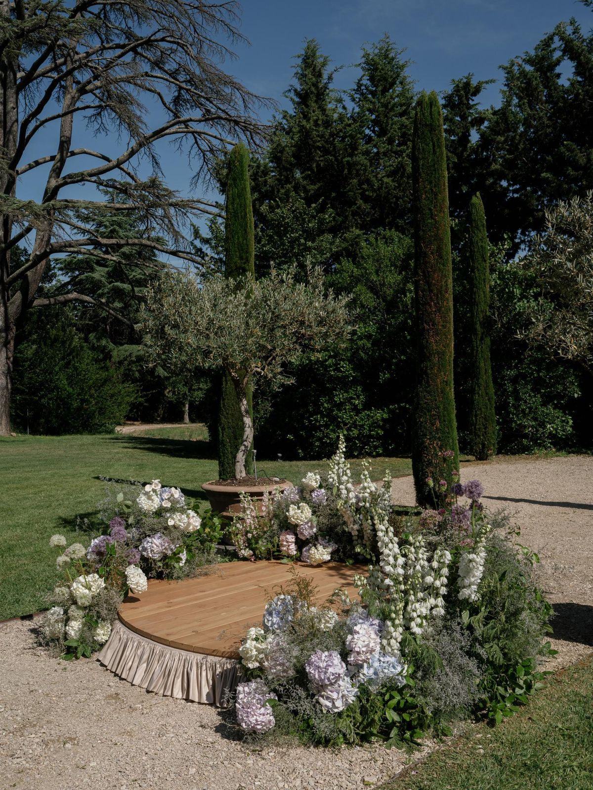 Floral ceremony arch set beneath mature trees