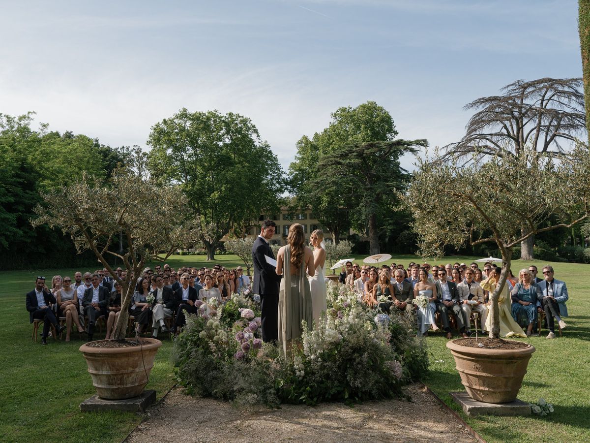 Ceremony seating beneath trees with guests gathered