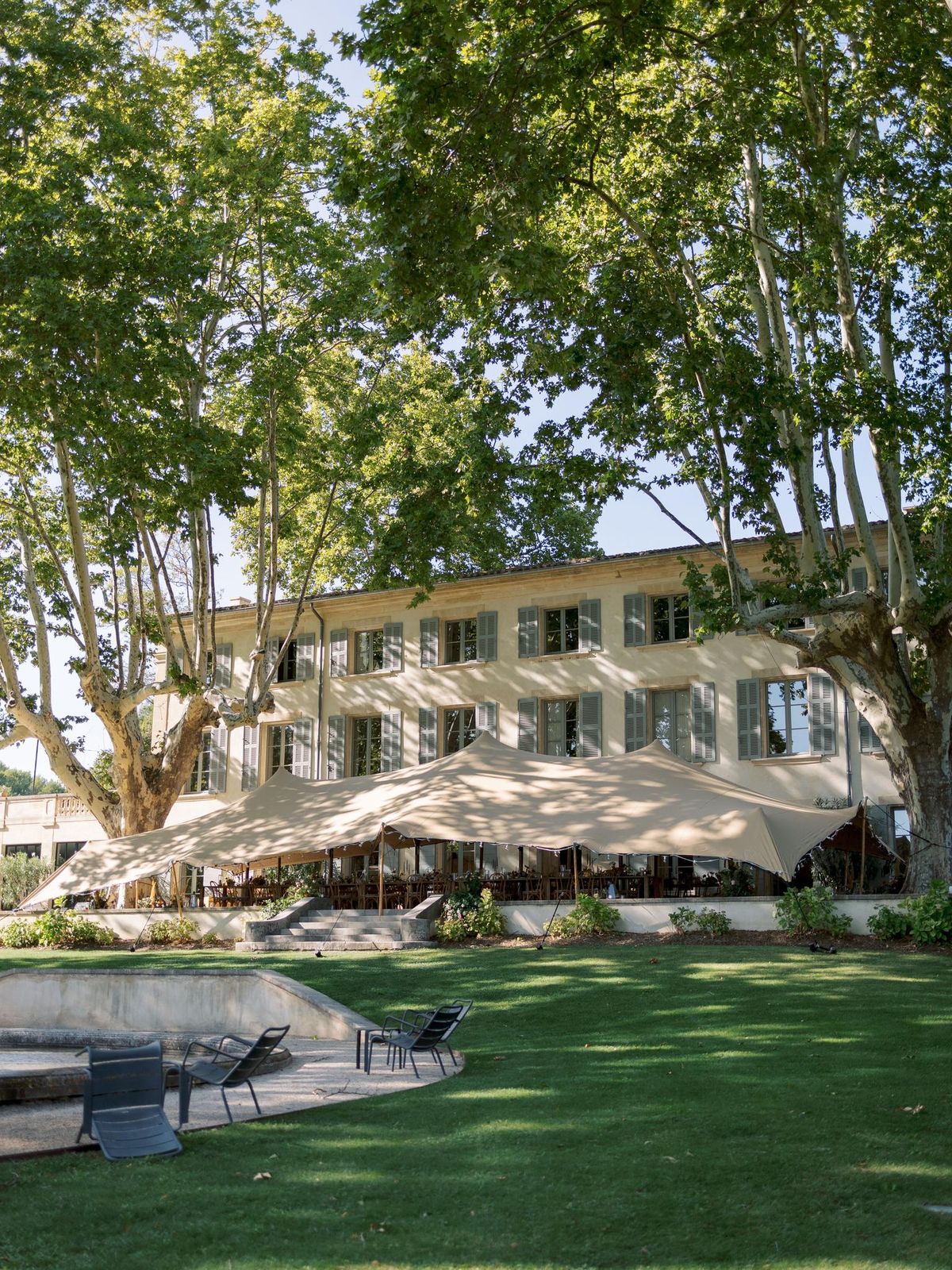 Chateau and swimming pool seen across the lawn