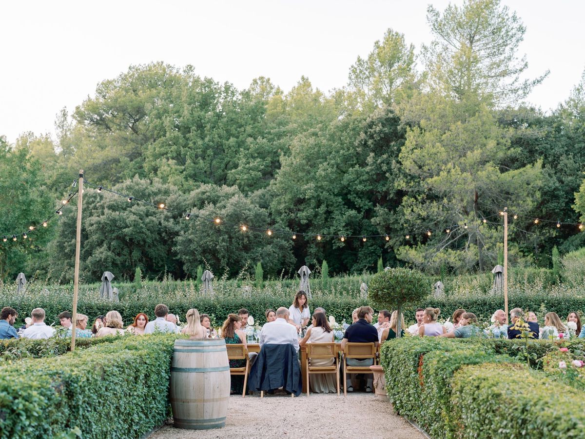 Guests dining outdoors beneath mature trees