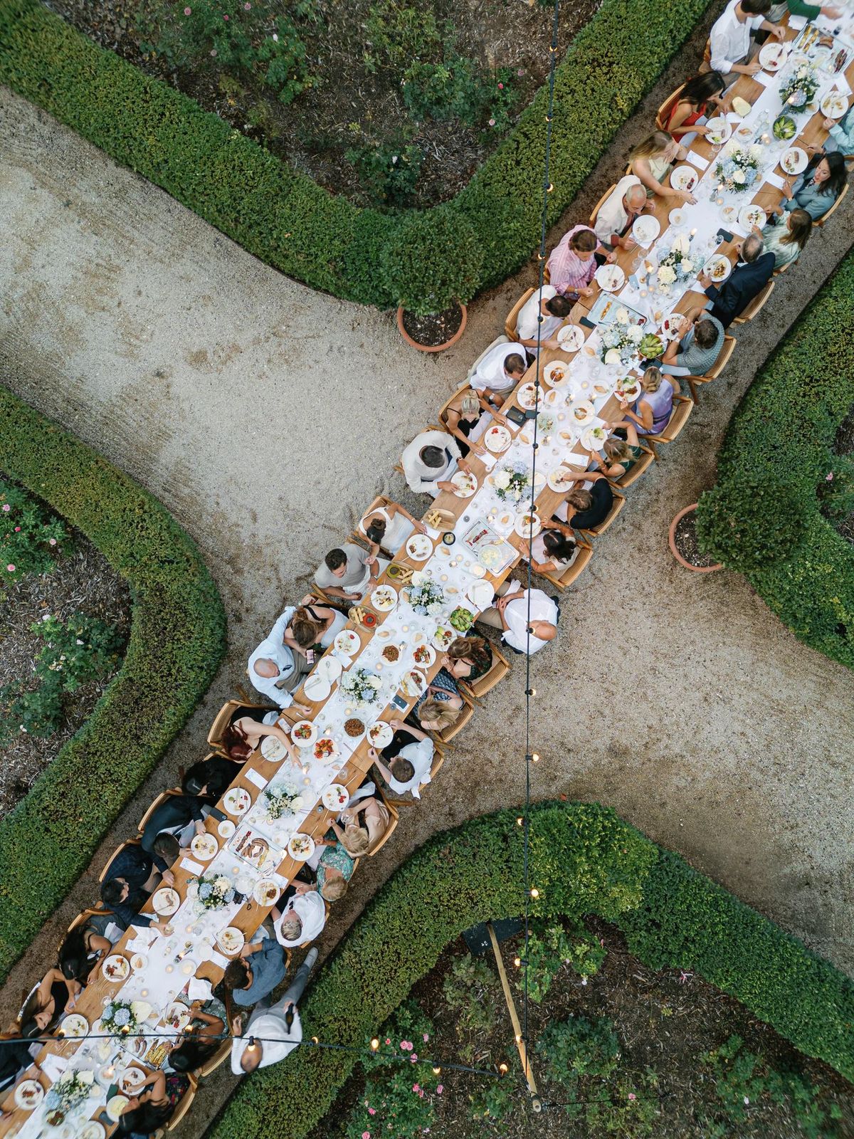 Aerial view of a long symmetrical dinner table in the garden