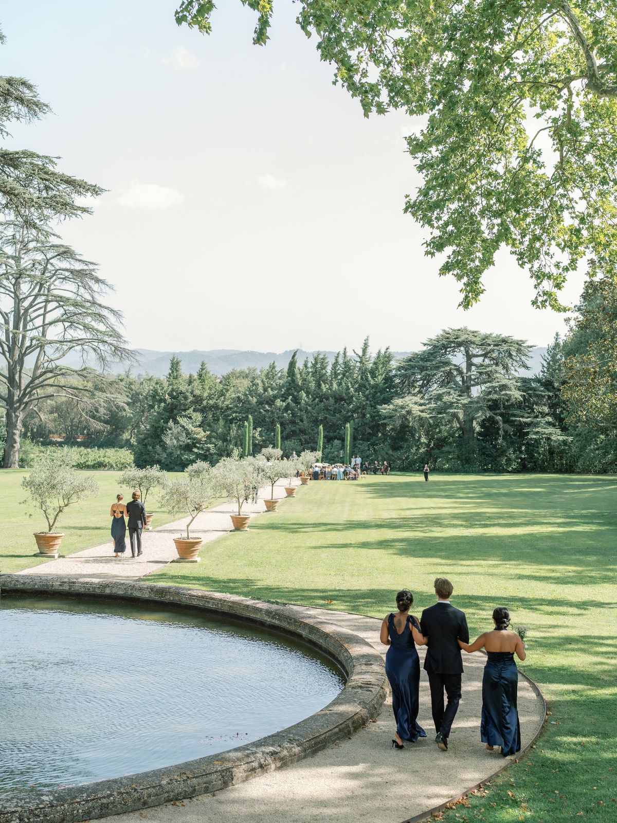 Guests gathered beside the pool with the chateau in view
