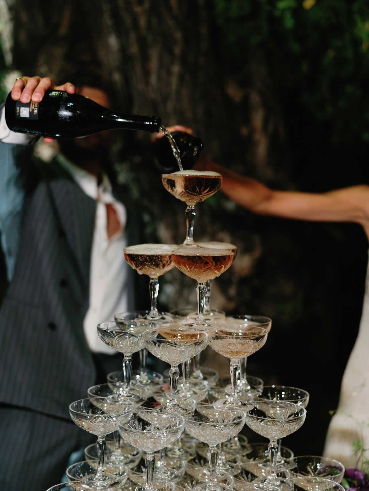Champagne tower being poured at the reception