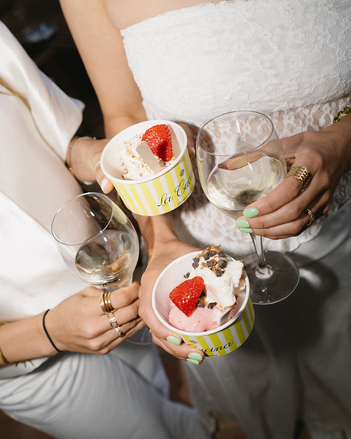 Dessert cups and champagne held by guests