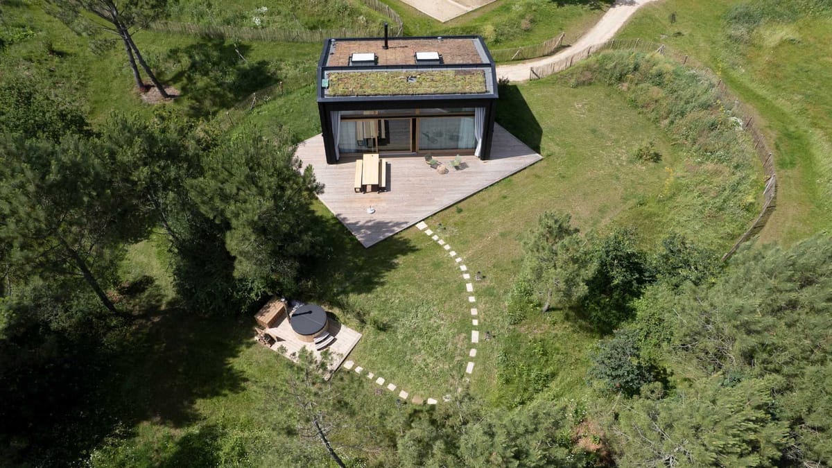 Aerial view of the eco lodge at Domaine Le Mezo with its green roof, timber deck and outdoor hot tub