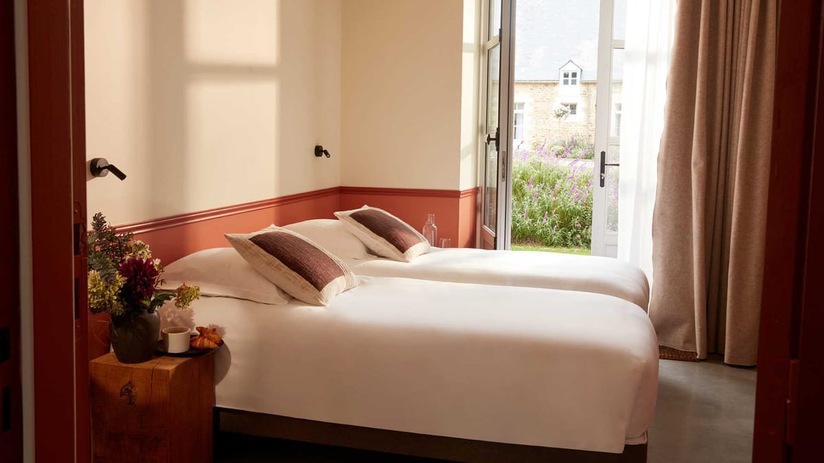 Twin room at Domaine Le Mezo with terracotta wainscot and doors opening onto the garden