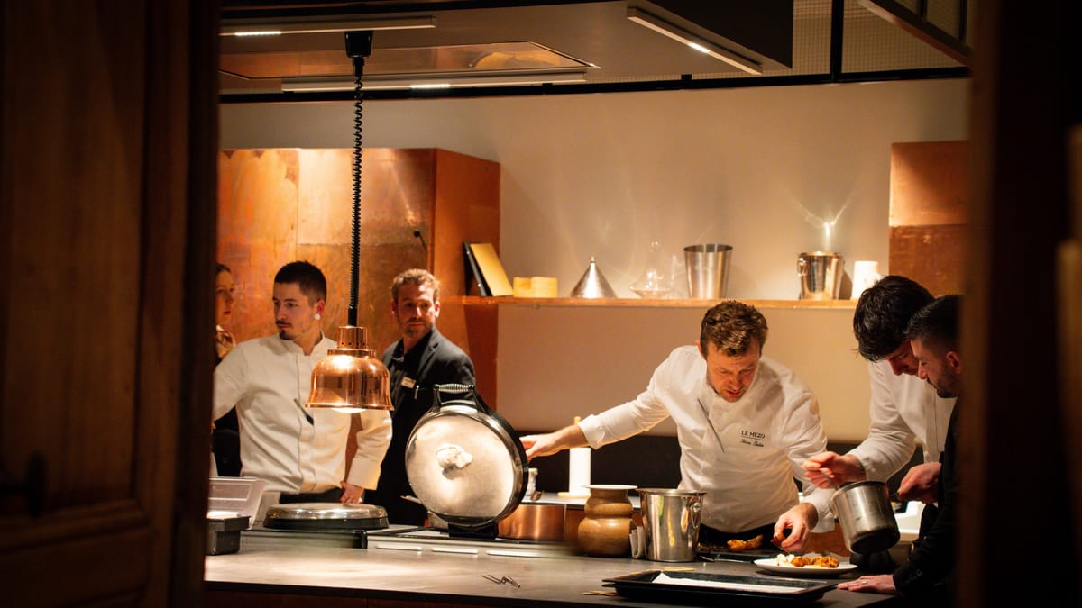 Chefs plating dishes at the kitchen pass at Domaine Le Mezo