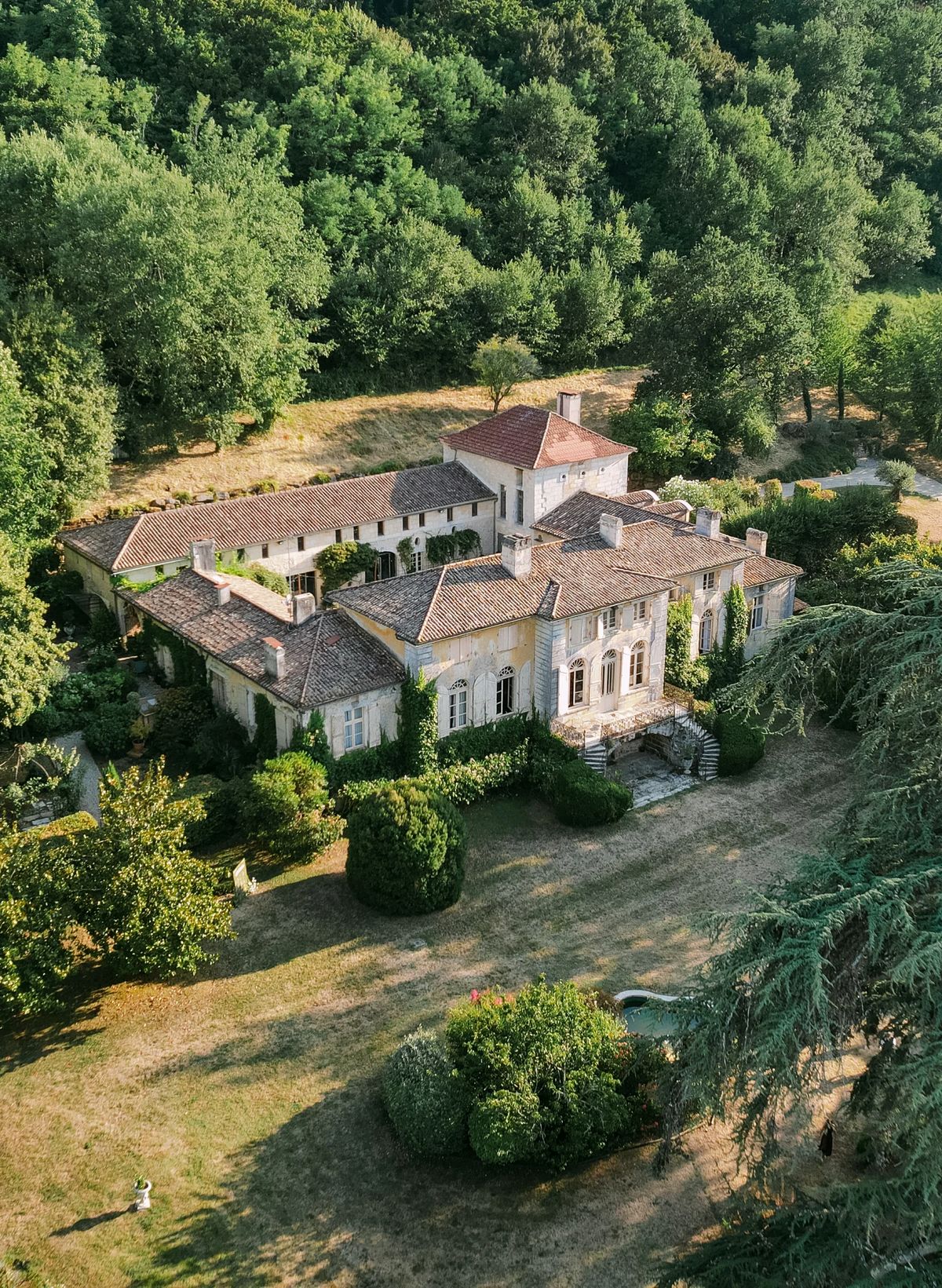 An aerial view of the house and its courtyards, surrounded by woodland