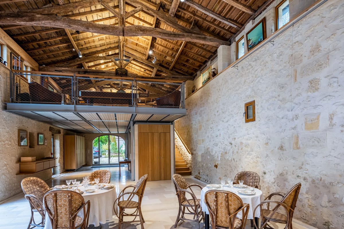 The Galerie Cédrus with its steel mezzanine, stone walls and set round tables