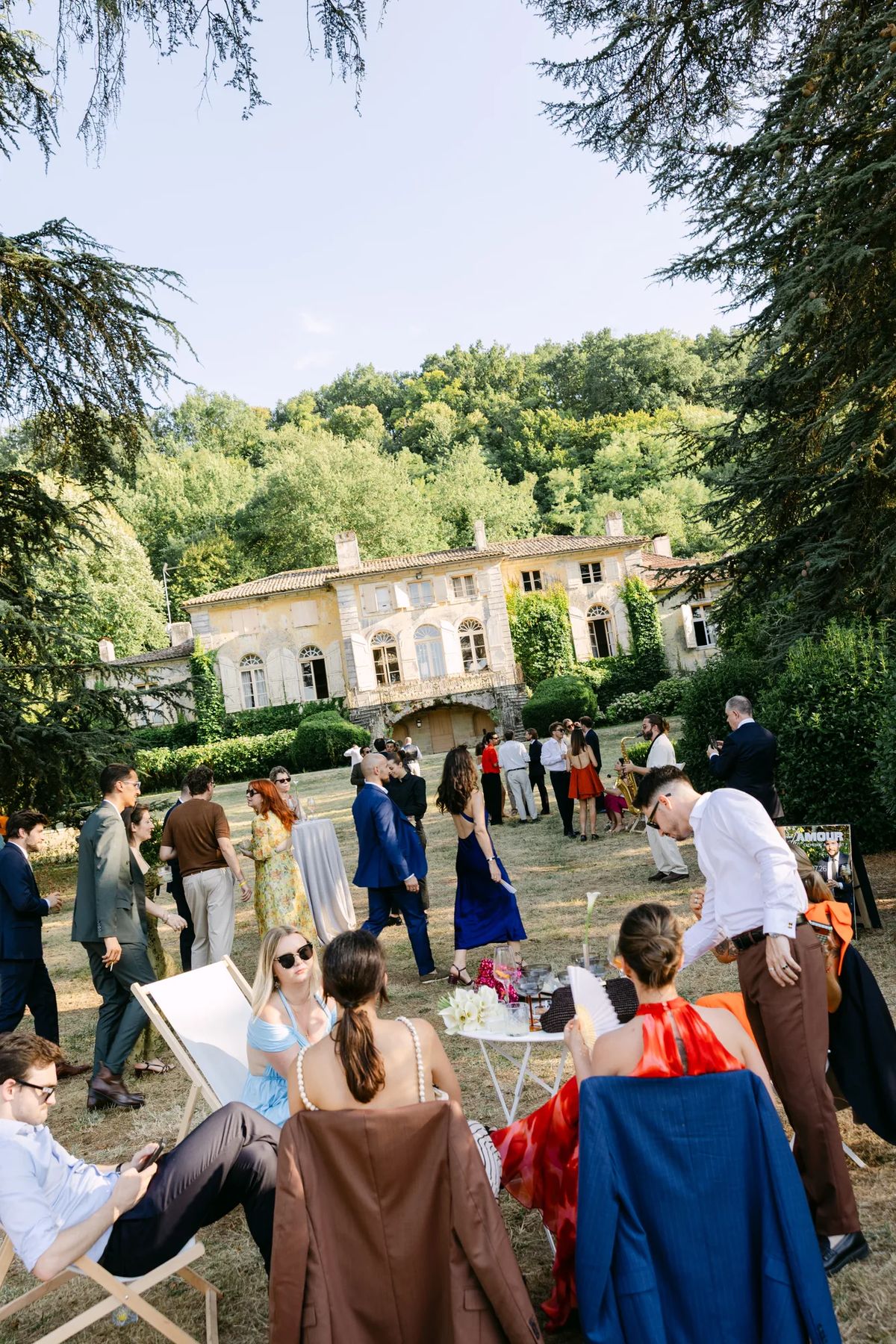 Guests at a garden reception on the lawn in front of the chateau